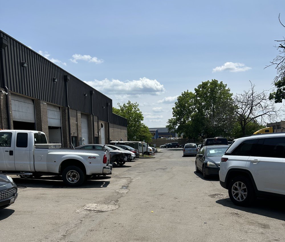 Customer vehicles parked outside the YBE Auto Repair Center service bays